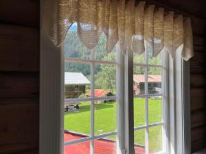 ein Fenster mit Blick auf einen grünen Hof in der Unterkunft Sevletunet B&B and Cabins in Rødberg