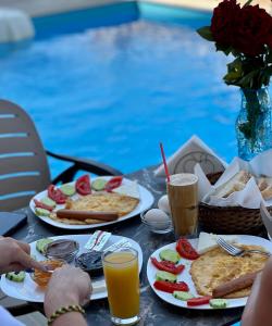una mesa con platos de comida y bebida junto a una piscina en Karos Hotel Llaman, en Himare