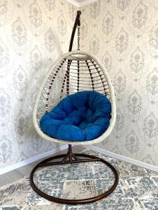 a blue cushion in a swinging chair in a room at Ясауи аппартамент in Türkistan