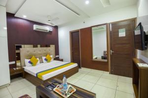 Schlafzimmer mit einem Bett, einem Tisch und einem Spiegel in der Unterkunft HOTEL LIME WOOD in Ludhiana