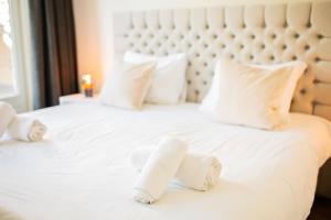 Una cama blanca con dos toallas. en Divine 50m2 Apartment, en Tiel