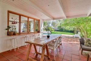 an open patio with a wooden table and chairs at Twistniet BnB in Wellington