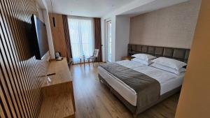 a bedroom with a large bed and a television at SIBB Hotel in Tirana
