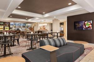 a restaurant with tables and chairs and a couch at Courtyard by Marriott Palmdale in Palmdale