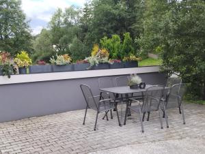 einen Tisch und Stühle auf einer Terrasse mit Pflanzen in der Unterkunft Apartmany FABRIK in Vysoká nad Kysucou