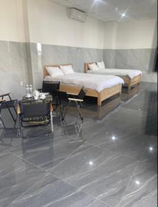 1 dormitorio con 1 cama, mesa y sillas en Ánh Mai Hotel, en Bao Loc