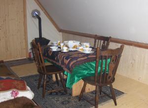 - une table à manger avec des tasses et des soucoupes dans l'établissement La Cabane du Trappeur V d N, à Voellerdingen