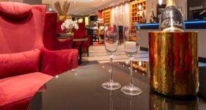 un tavolo con una bottiglia di champagne e due bicchieri di vino di PLAZA Premium Köln a Colonia