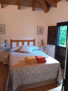 um quarto com uma cama com duas toalhas em Casa rural en Asturias a orillas del río Narcea puerta de Somiedo em Bárzana