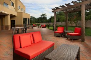 a patio with red cushioned chairs and a pergola at Courtyard by Marriott Waldorf in Waldorf