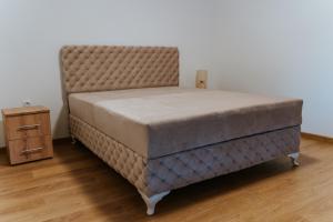 a bed with a tufted headboard and a night stand at B&B LUX Pavlovci in Pavlovci +17 photos