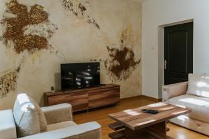a living room with a tv and a couch and a table at B&B LUX Pavlovci in Pavlovci