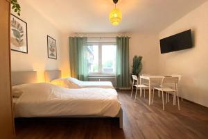 - une chambre avec un lit, une table et des chaises dans l'établissement Cozy Apartment in Oberhausen, à Oberhausen