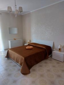 ein Schlafzimmer mit einem Bett mit einer braunen Decke in der Unterkunft La Reggia del Corso in Vieste