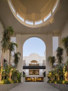eine offene Lobby mit Palmen und einem großen Fenster in der Unterkunft Serry Beach Resort in Hurghada