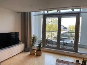 a living room with a flat screen tv and potted plants at Bremen Weser Best View Apartment in Bremen