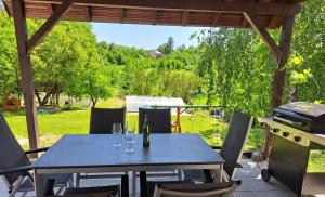 a table with wine glasses and a grill on a patio at Rekreační Domek Litenčice na Jižní Moravě in LitenÄice