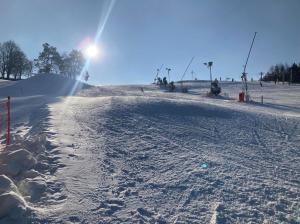 a snow covered ski slope with the sun in the background at Rekreační Domek Litenčice na Jižní Moravě in LitenÄice