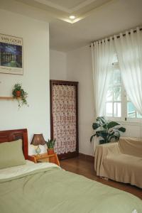 a bedroom with two beds and a window at Art Garden Dalat in Da Lat