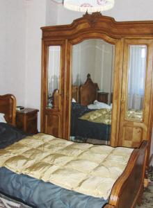 1 dormitorio con cama y espejo grande en La Cabane du Trappeur V d N, en Voellerdingen