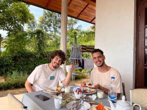 two men sitting at a table eating food at Lakeside Garden Bungalow 湖畔花园山居 in Nuwara Eliya +31 photos