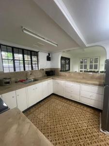 een grote keuken met witte kasten en een wastafel bij Spacious House in Tagaytay near Skyranch (6pax) in Tagaytay