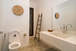 a white bathroom with a toilet and a sink at Villa Kama in Rawai Beach