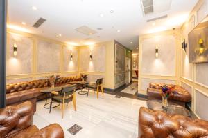 a lobby with leather couches and a table and chairs at Premist Hotels Taksim in Istanbul