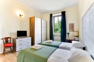 1 dormitorio con 2 camas, TV y ventana en Appartamento Napoli 25 - Affitti Brevi Italia, en Milán