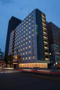 a tall black building with windows on a city street at Tmark City Hotel Sapporo Odori in Sapporo