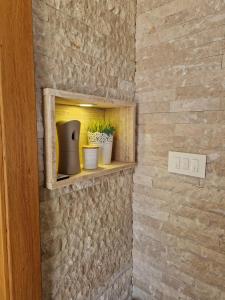 a brick wall with a shelf with plants in it at Apartman "EXCLUSIVE" in Bihać