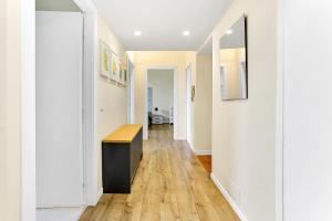 un corridoio di una casa con pareti bianche e pavimenti in legno di Appartamento Napoli 25 - Affitti Brevi Italia a Milano