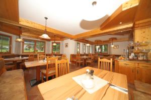 a restaurant with wooden tables and wooden chairs at Hotel Cafe' Hermann in Schladming