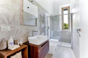 y baño blanco con lavabo y ducha. en Appartamento Napoli 25 - Affitti Brevi Italia, en Milán