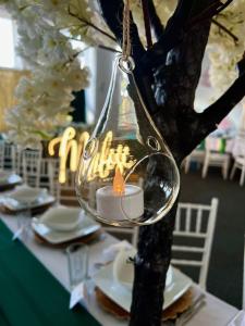 a candle in a wine glass hanging from a tree at Royal House in Białogard