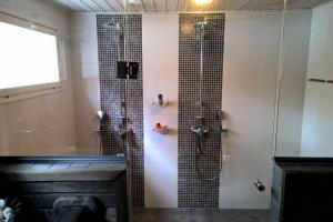 a bathroom with a shower with a glass door at Omakotitalo Vierumäellä X A house near Vierumäki sports center in Heinola