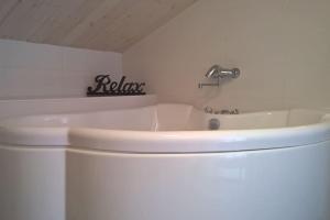 a white bathroom with a tub and a sink at Omakotitalo Vierumäellä X A house near Vierumäki sports center in Heinola +2 photos