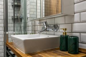 een wastafel in de badkamer met een kraan en twee groene flessen bij Synagogue Central Kira Apartment in Boedapest