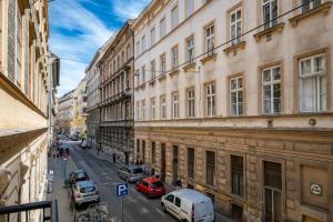 een stadsstraat met geparkeerde auto's en gebouwen bij Synagogue Central Kira Apartment in Boedapest
