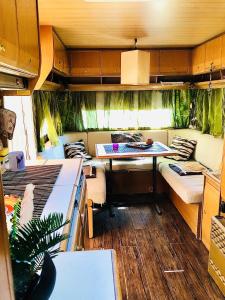 a rv with a table and a room with beds at Caravan on the beach, pet friendly in Corbu
