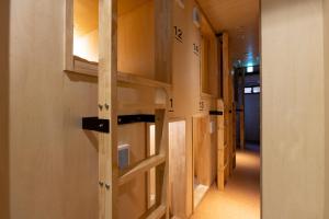 a hallway with wooden shelves on the wall at Cafe & Guest House Nagonoya in Nagoya