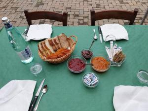 - une table verte avec un panier de pain et une bouteille d'eau dans l'établissement Cascina Zanot, à Marsaglia