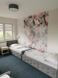 - 2 lits dans une chambre avec papier peint floral dans l'établissement Rezydencja Pod Pieprzówkami, à Zalesie Gorzyckie