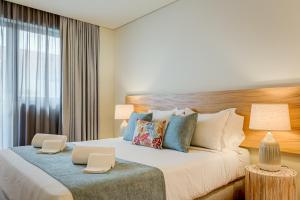 波尔图Blissful Suites Porto by gaiarooms的一间卧室，有一张大床，配有两盏灯