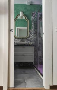 La salle de bains est pourvue d'un lavabo et d'un miroir. dans l'établissement Capinera Luxury, à Catane