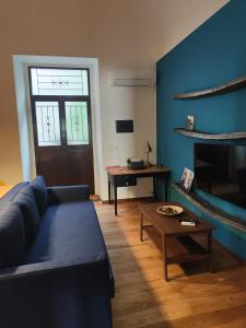 - un salon avec un canapé bleu et une table dans l'établissement Capinera Luxury, à Catane