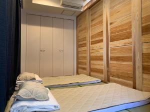 2 letti in una camera con pareti in legno di 青嵐ペンション海まで50M Pension Seiran is only 50m from the coast a Isa