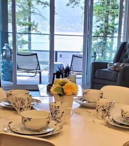 una mesa con tazas de té y platillos en ella en Lake View Beach, Marina, Pool, HT, en Kelowna