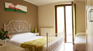a bedroom with a white bed and a sliding glass door at Alexander Rooms in Tirano