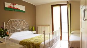 una camera con letto bianco e porta scorrevole in vetro di Alexander Rooms a Tirano